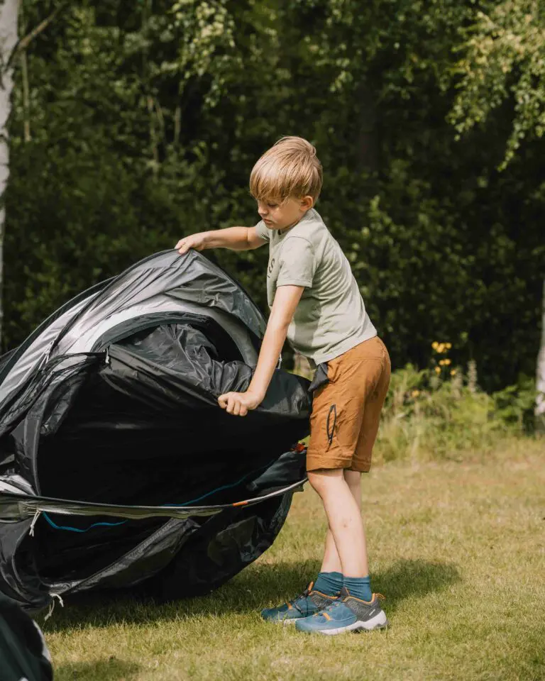 Un enfant qui déplie sa tente lors de son aventure au Canoë Trip.