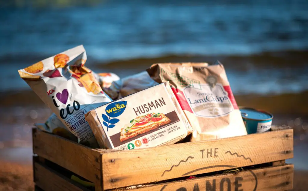 caisse en bois remplie de snacks suédois sur une plage