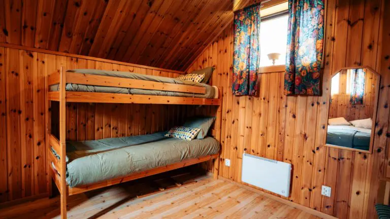 lits superposés dans une chambre chaleureuse de chalet en bois