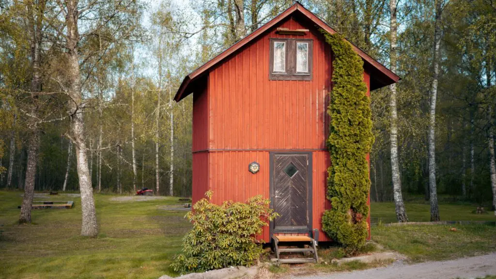 cabane de bûcheron rouge dans une clairière forestière