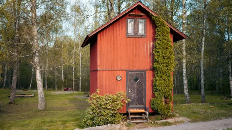 cabane de bûcheron rouge dans une clairière forestière