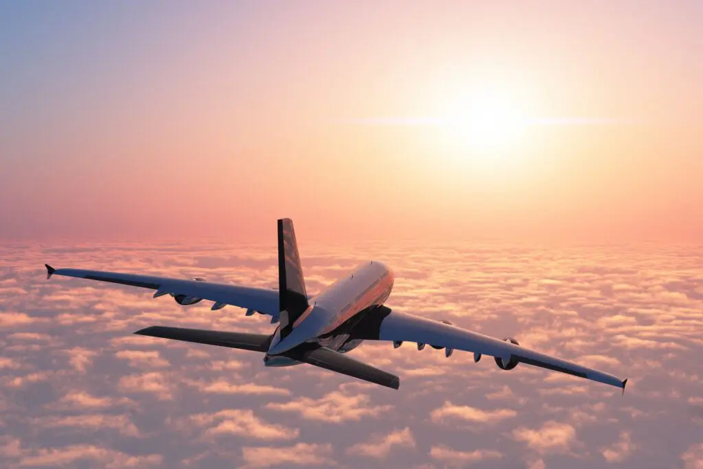 avion volant au-dessus des nuages au coucher du soleil