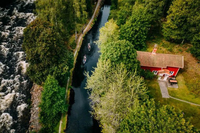 vue aérienne de deux canoës sur un canal à côté d’une maison rouge