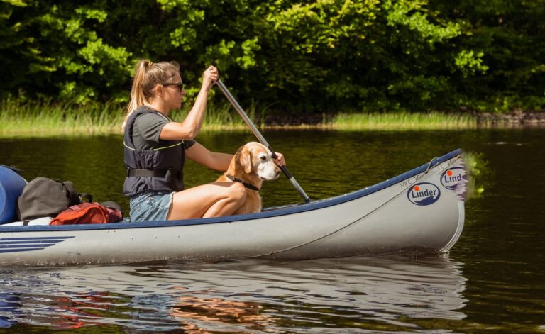 Femme avec chien en canoë.